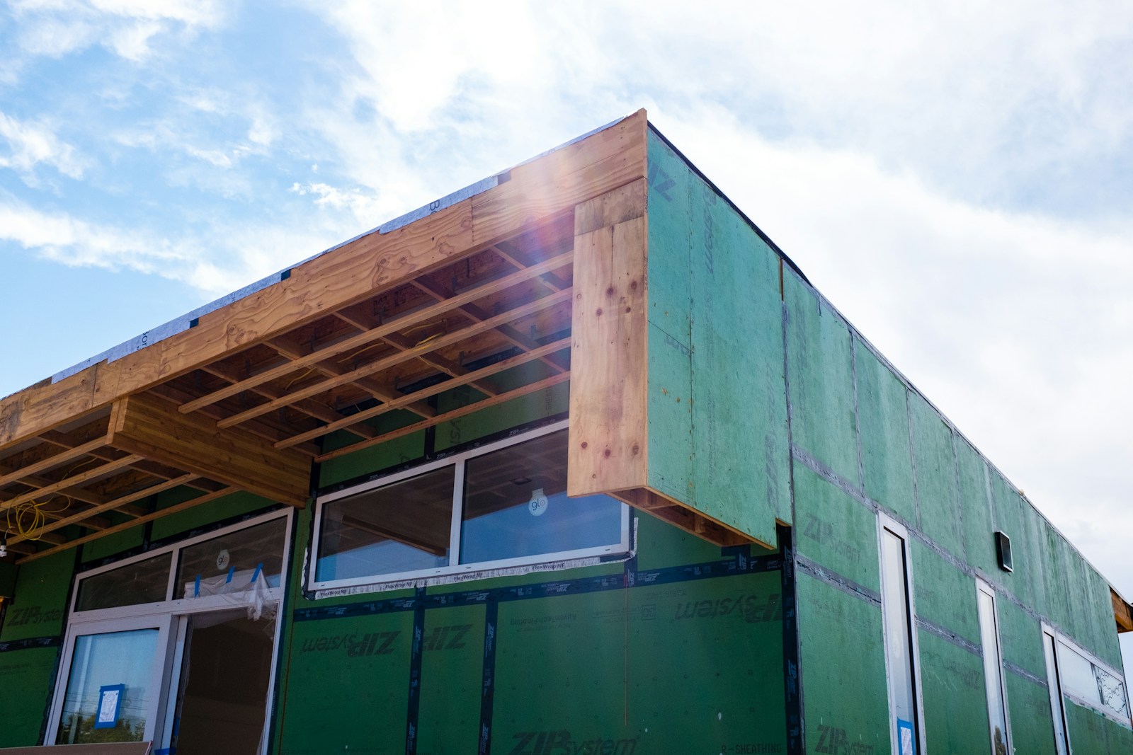 House framing under construction against a blue sky